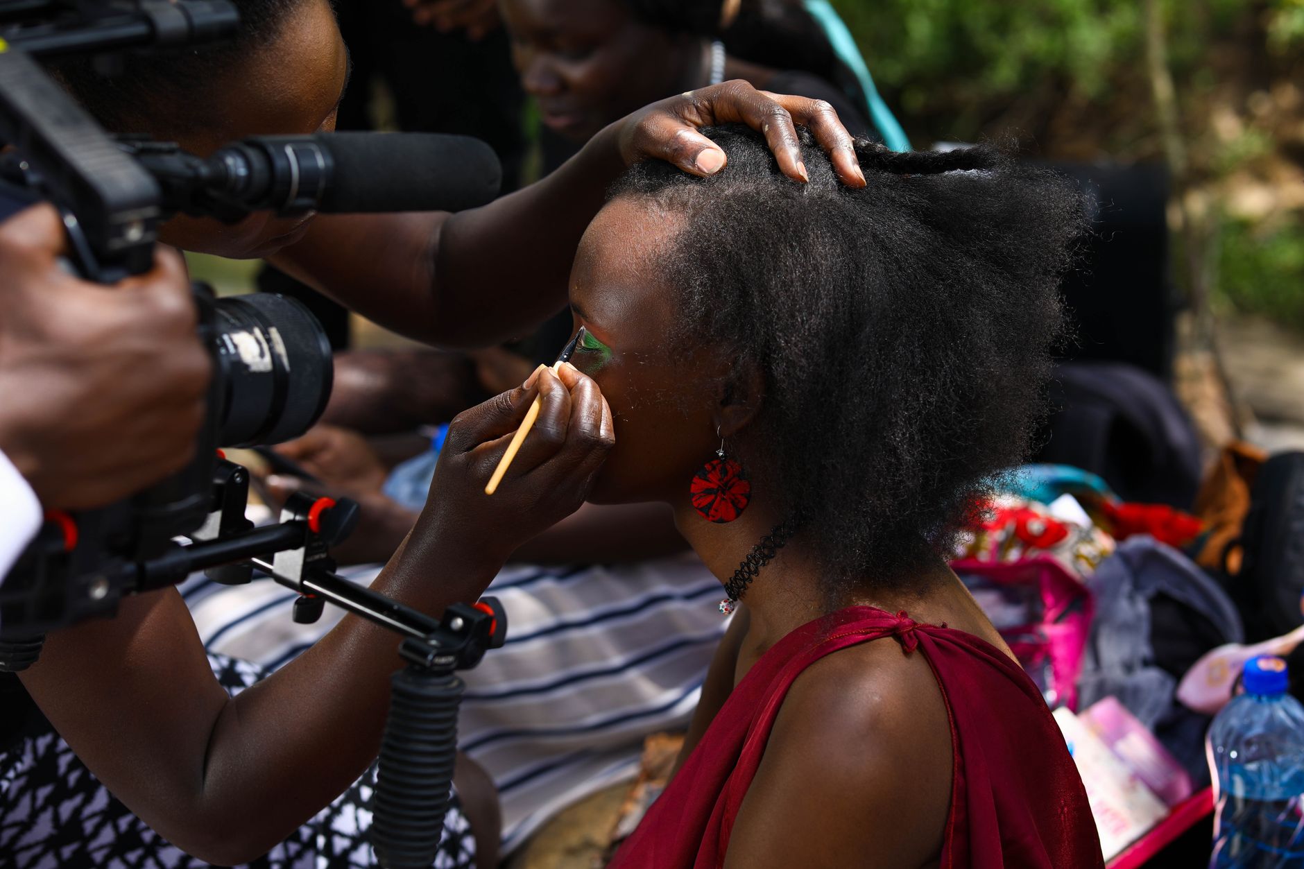 African filmmaker capturing behind-the-scenes content for a brand video shoot outdoors