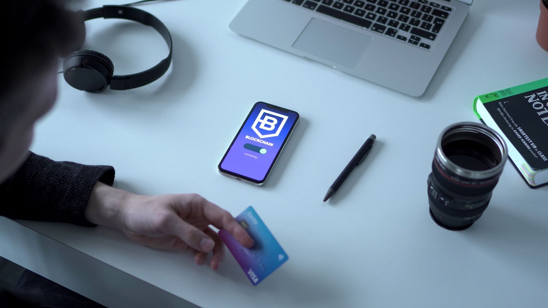 Person holding a virtual Visa card next to a smartphone running a fintech payment app