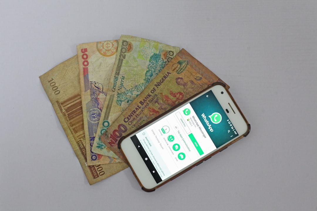SEO vs Google Ads for Nigerian Startups With ₦500k Nigerian naira banknotes fanned out next to a smartphone showing a mobile app — representing Google Ads budget spend and ROI in Nigeria