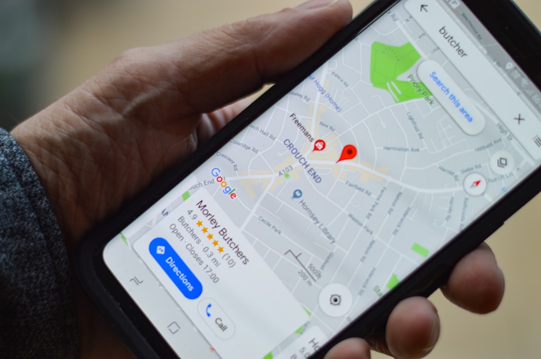 Hand holding a smartphone showing a Google Maps business listing with star ratings and directions button