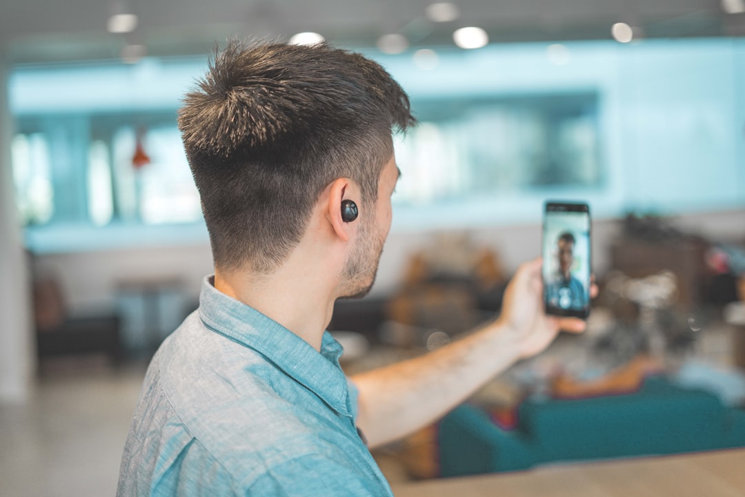 Person holding up a smartphone to record a video, demonstrating the video verification process