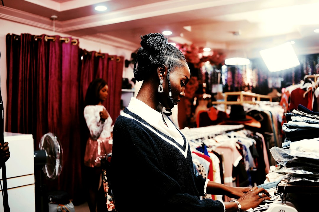 SEO vs Google Ads for Nigerian Startups With ₦500k African woman browsing clothes in a boutique clothing store, illustrating the Surulere fashion boutique local SEO example